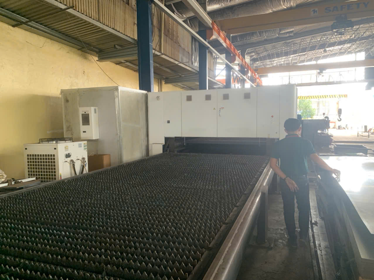 CNC laser cutting machine in Vietnamese factory producing precision sheet metal parts